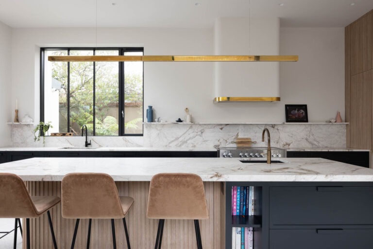 Bespoke navy and oak kitchen island with brass pendant light and marble countertop, handmade by Woodale Designs in Ireland.